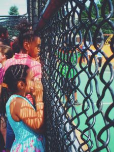 Skiddy Park soccer court with children watching players on the field separated by a chain link fence