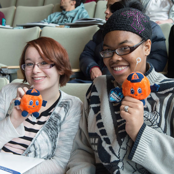 Students holding Otto the Orange dolls