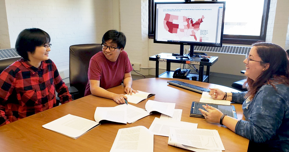 Students at table looking at papers