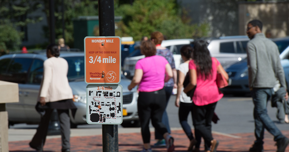 Monday Miles 3/4 Mile Sign with people walking behind it