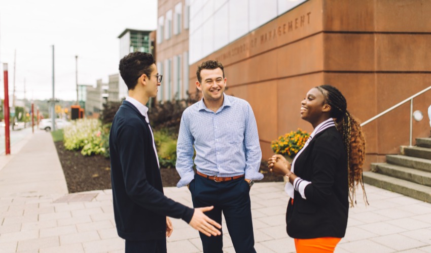 students chatting in front of the Whitman School of Management