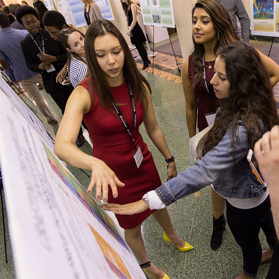 Students presenting at poster session in Maxwell Hall.