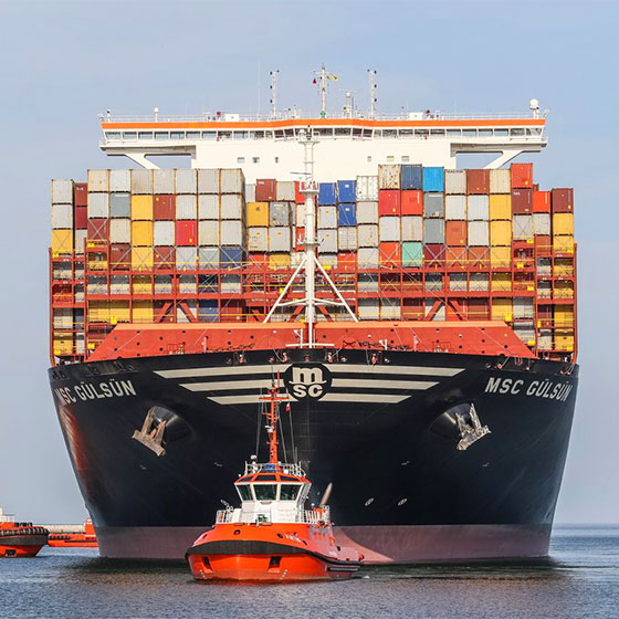 Shipping containers on a boat with smaller tugboat