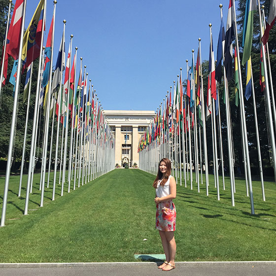 Student outside in front of lines of flags