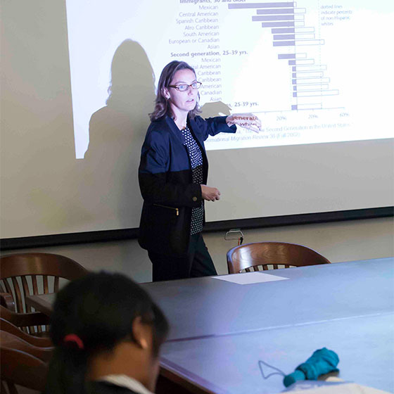 Person presenting at the front of a classroom