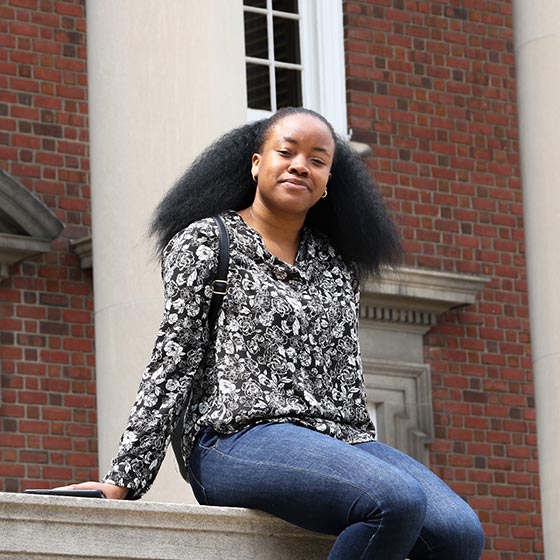 Student in courtyard sitting on wall