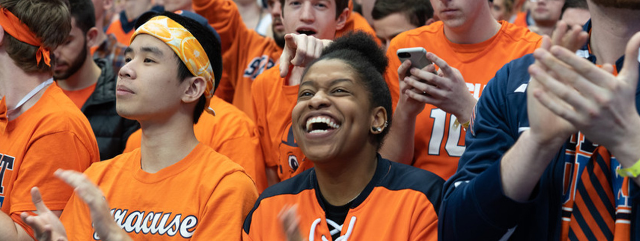 students in orange clothes clapping