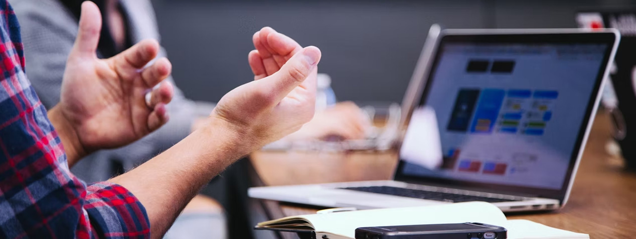 Person's hands and computer in background