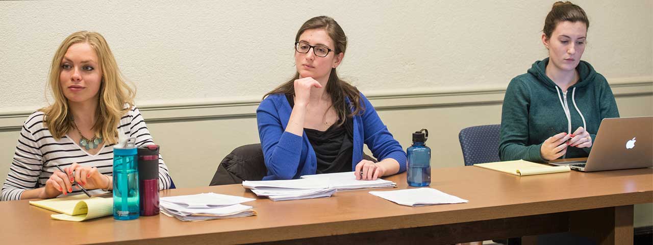 Three students sitting in a classroom