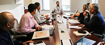 Chris Skaluba at Conference Table with students