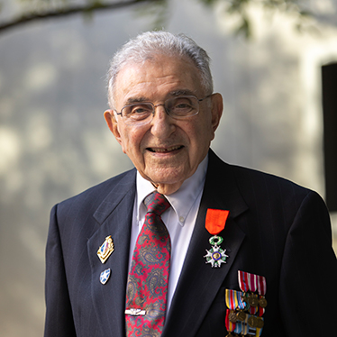 Photo of Ralph Hockley with military honors pinned to his suit jacket