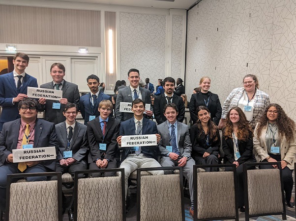 Students sitting together with "Russian Federation" signs