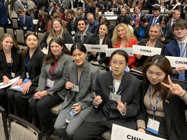 Group of students sitting in chairs holding signs that say China